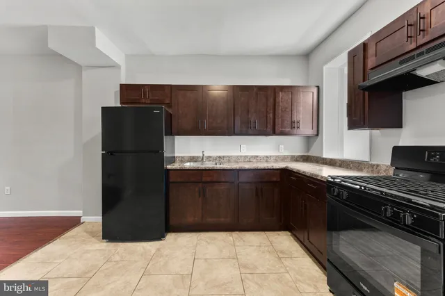 a kitchen with a refrigerator and a stove top oven