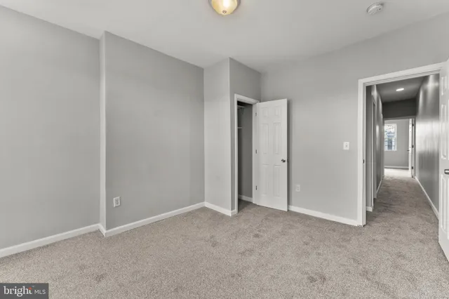 an empty room with closet area and bathroom