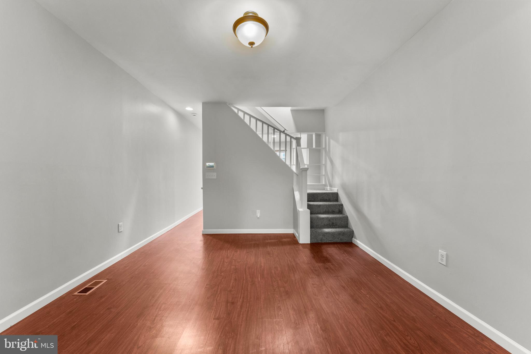 1249 Carroll Street Baltimore, MD 21230 - Photo 8 of 29 a view of an empty room with wooden floor and stairs