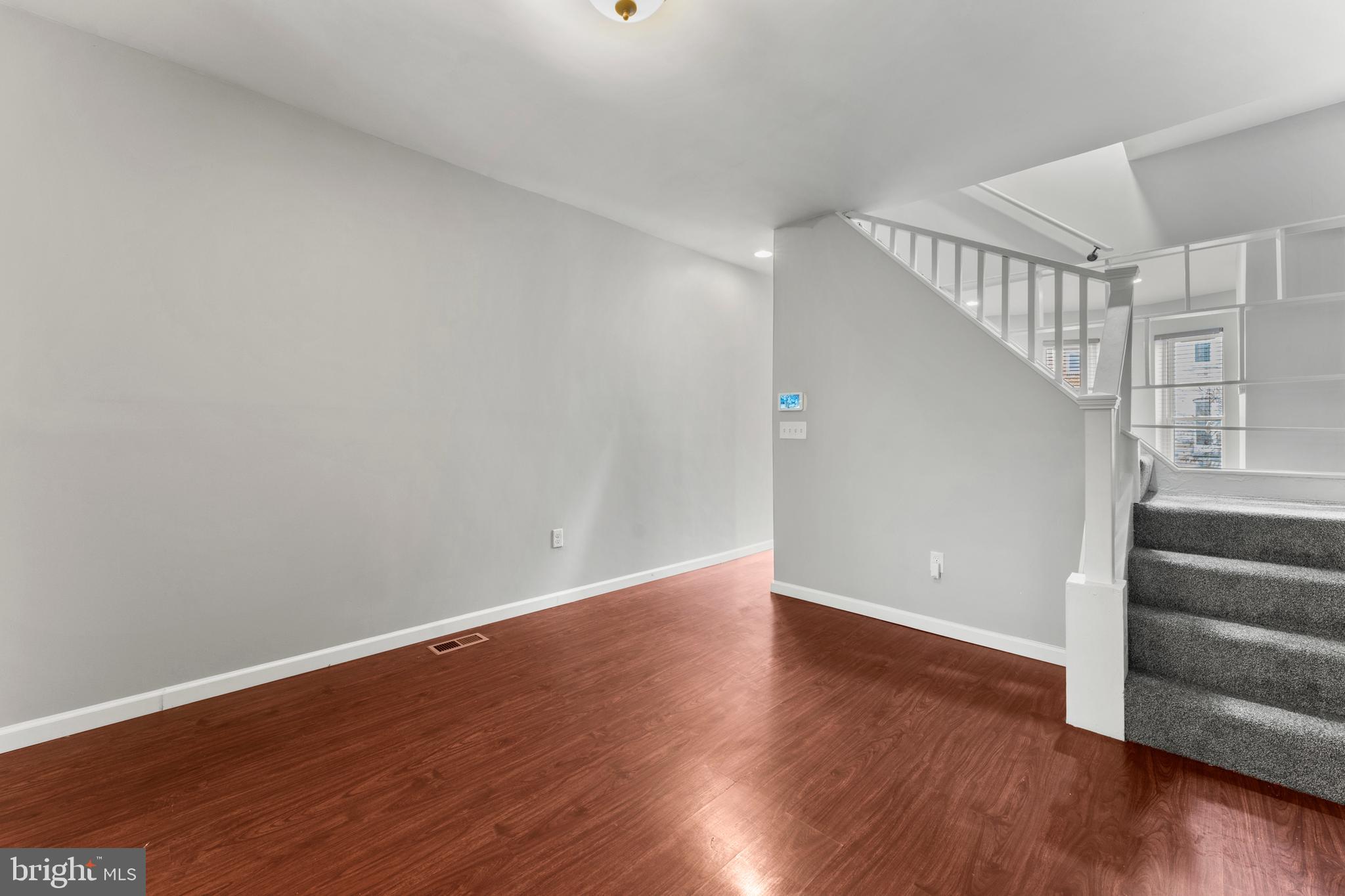 1249 Carroll Street Baltimore, MD 21230 - Photo 9 of 29 a view of an empty room with wooden floor and stairs