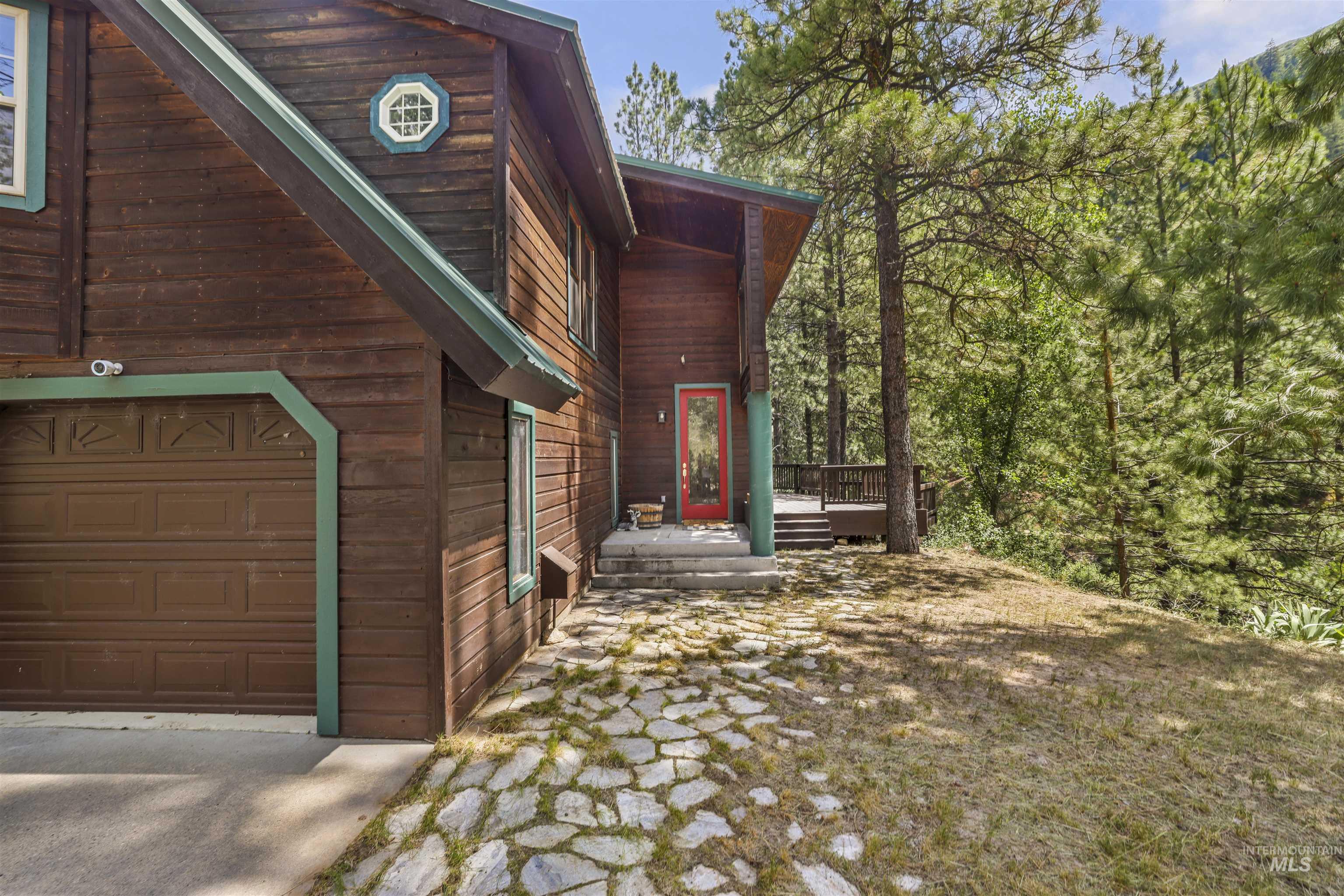 224 Dakota Road Mountain Home, ID 83647 - Photo 40 of 50 Wood-sided exterior featuring a prominent red entry door and an attached garage