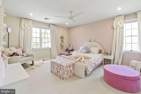 a spacious bedroom with a bed couch and window