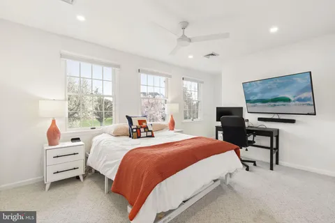 a large bed sitting in a bedroom next to a window and a dresser