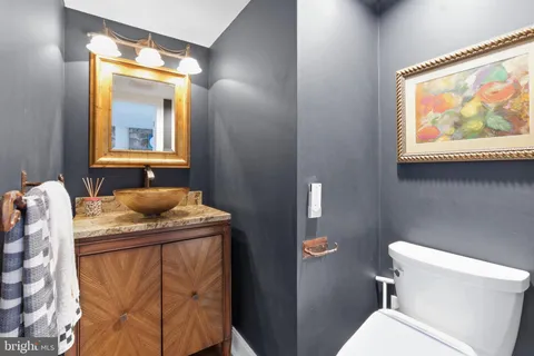 a bathroom with a granite countertop sink mirror vanity and toilet