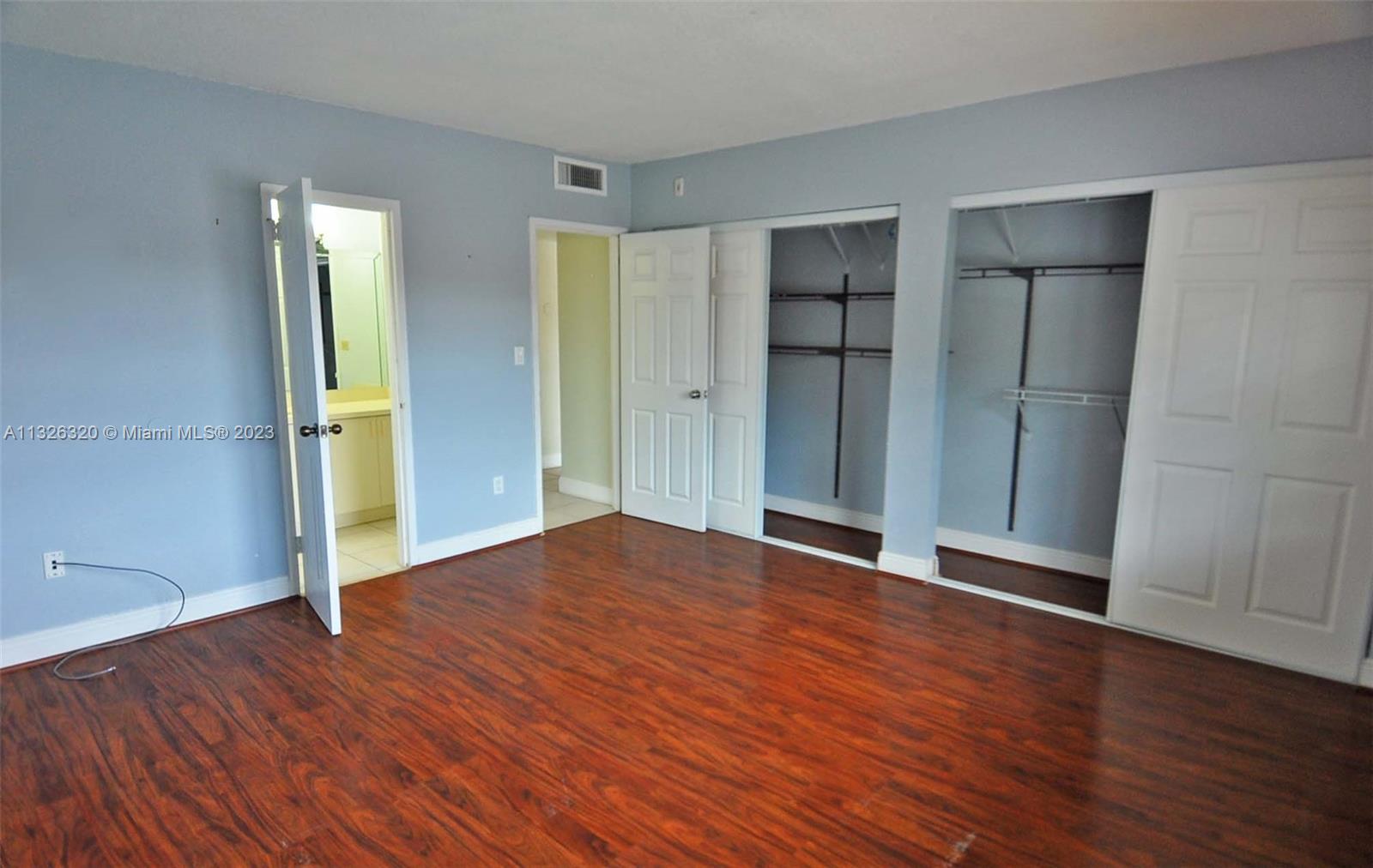 9972 Southwest 88th Street, Unit 1121 Miami, FL 33176 - Photo 4 of 7 an empty room with wooden floor and closet area