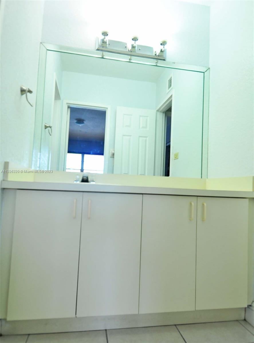 9972 Southwest 88th Street, Unit 1121 Miami, FL 33176 - Photo 5 of 7 a bathroom with a sink and a mirror