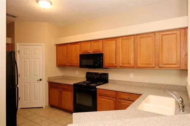 a kitchen with granite countertop a refrigerator and cabinets