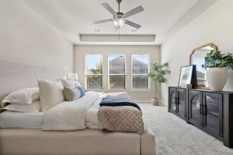 a bedroom with a large bed and a chandelier
