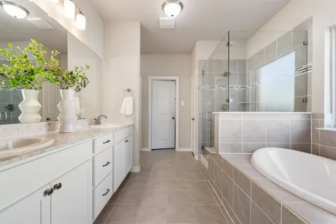 a spacious bathroom with a granite countertop sink a toilet a mirror and shower