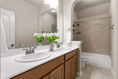 a bathroom with a granite countertop sink a toilet and shower