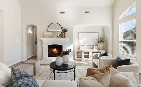 a living room with furniture a fireplace and a large window