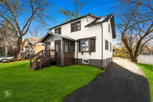 a view of a house with a big yard and large trees