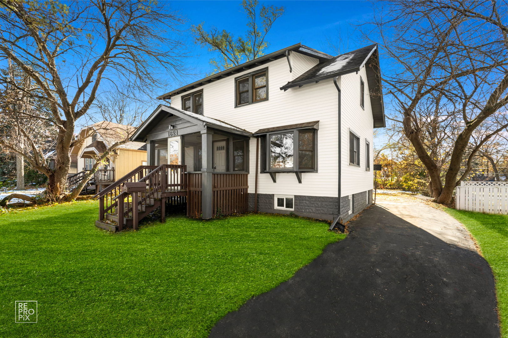 a view of a house with a big yard and large trees