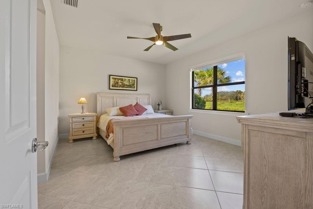 5931 Mayflower Way Ave Maria, FL 34142 - Photo 11 of 34 a bedroom with a bed and a flat tv screen on the dresser