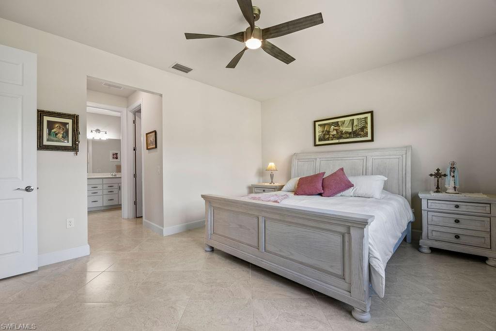 5931 Mayflower Way Ave Maria, FL 34142 - Photo 12 of 34 a bedroom with a bed and a chandelier