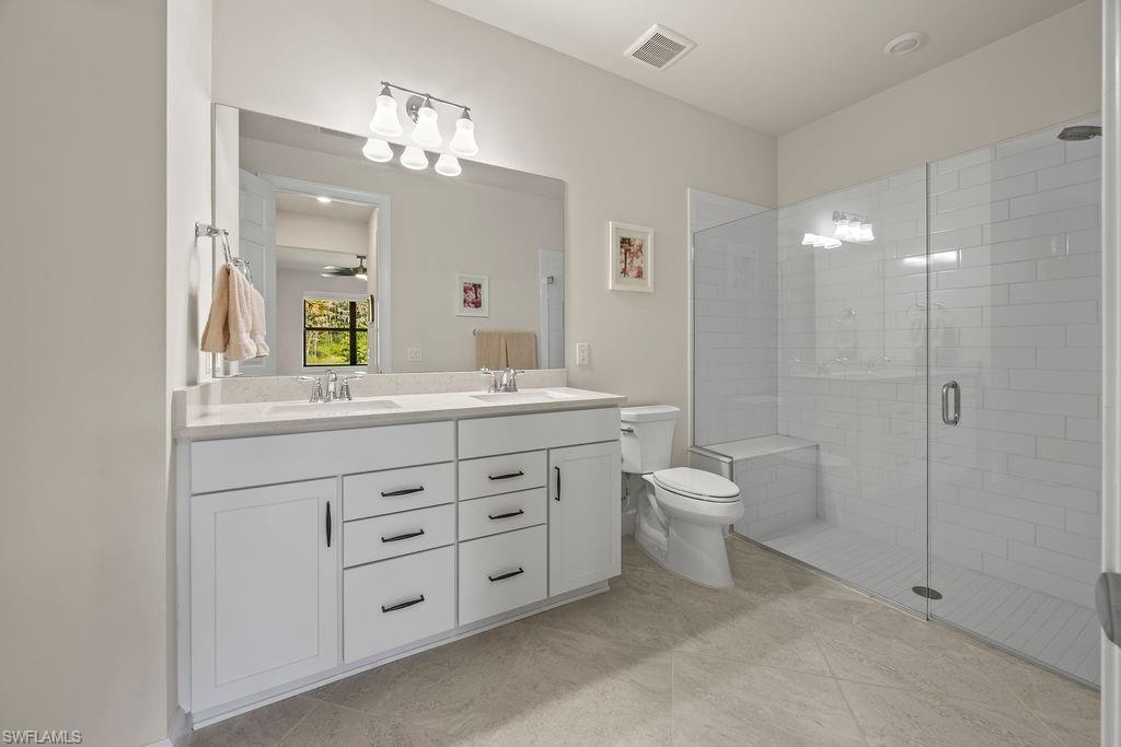 5931 Mayflower Way Ave Maria, FL 34142 - Photo 14 of 34 a bathroom with a double vanity sink mirror and toilet