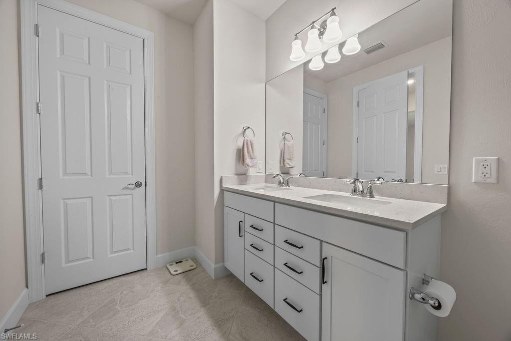 5931 Mayflower Way Ave Maria, FL 34142 - Photo 15 of 34 a bathroom with double sink and a mirror
