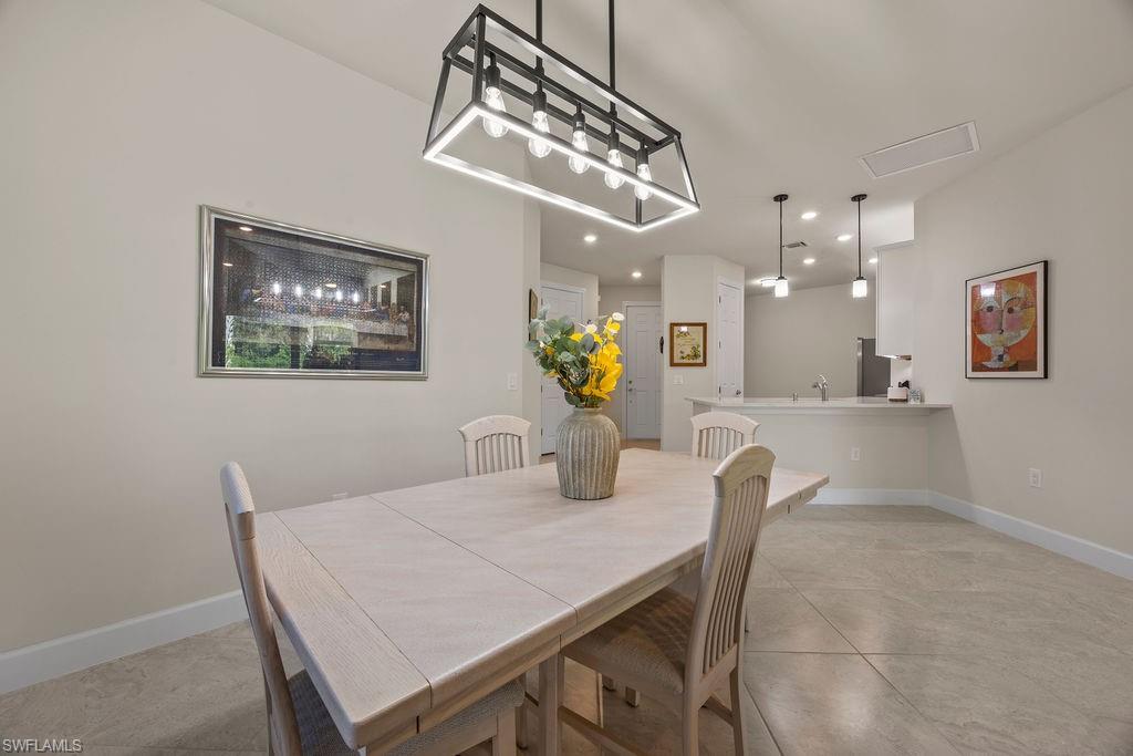 5931 Mayflower Way Ave Maria, FL 34142 - Photo 19 of 34 a view of a dining room with furniture and chandelier
