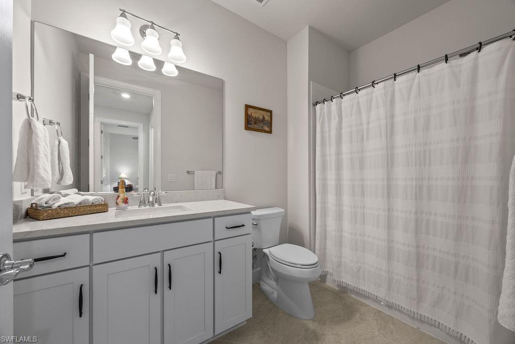 5931 Mayflower Way Ave Maria, FL 34142 - Photo 24 of 34 a bathroom with a double vanity sink toilet and a mirror