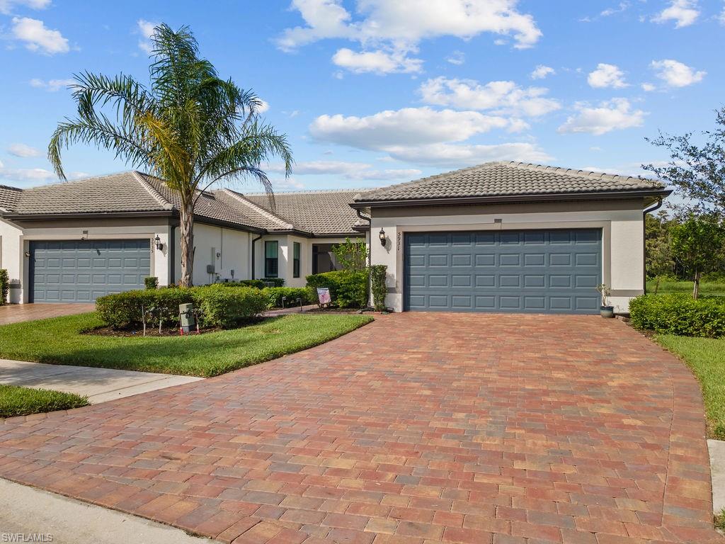 5931 Mayflower Way Ave Maria, FL 34142 - Photo 28 of 34 a front view of a house with a yard and garage