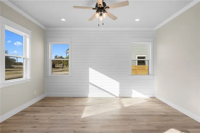 a view of a hallway with wooden floor and chandelier