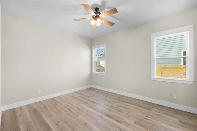 an empty room with a window and a fan