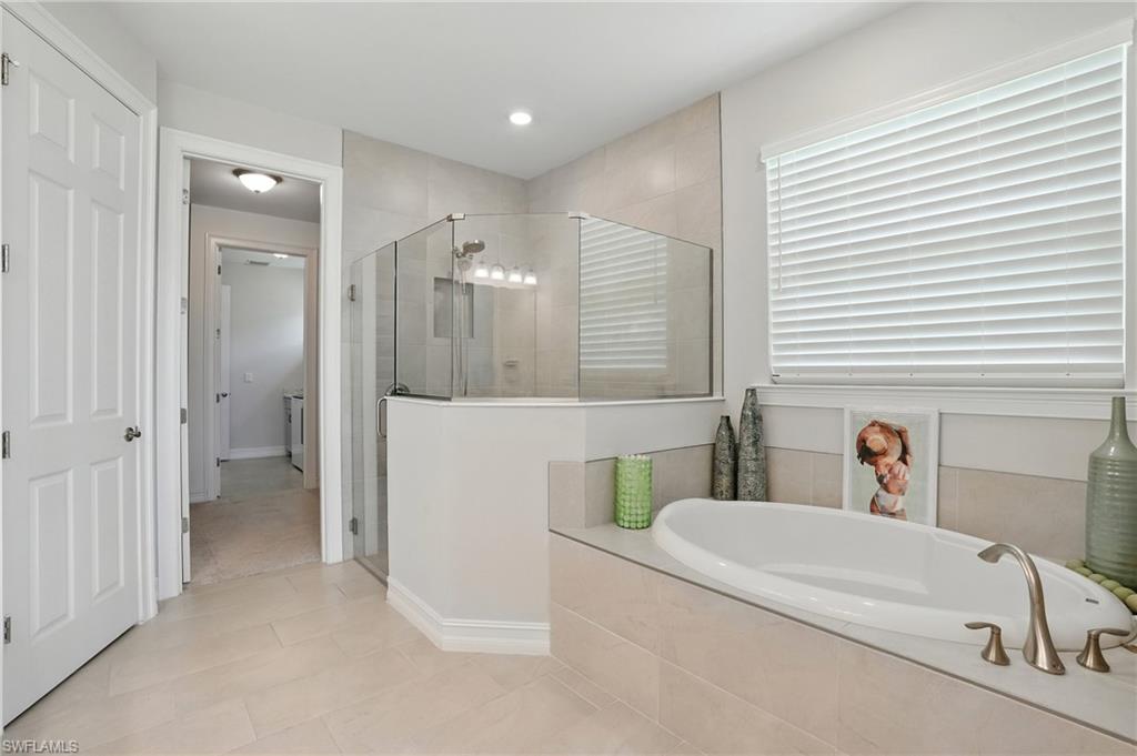 28165 Captiva Shell Loop Bonita Springs, FL 34135 - Photo 18 of 38 a bathroom with a tub sink and mirror