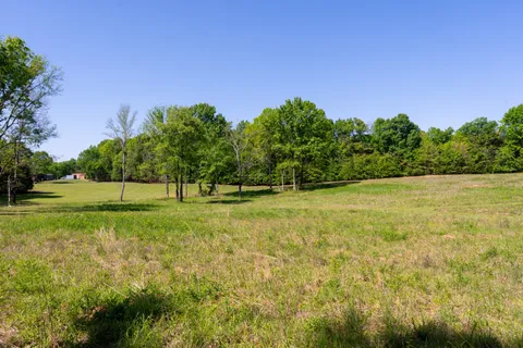 a front view of house with yard and trees in the background
