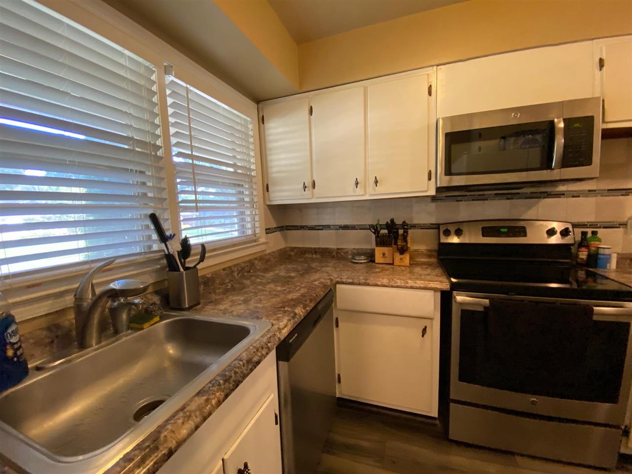 1265 Whitewater Road Memphis, TN 38117 - Photo 4 of 23 a kitchen with stainless steel appliances granite countertop a sink stove and microwave