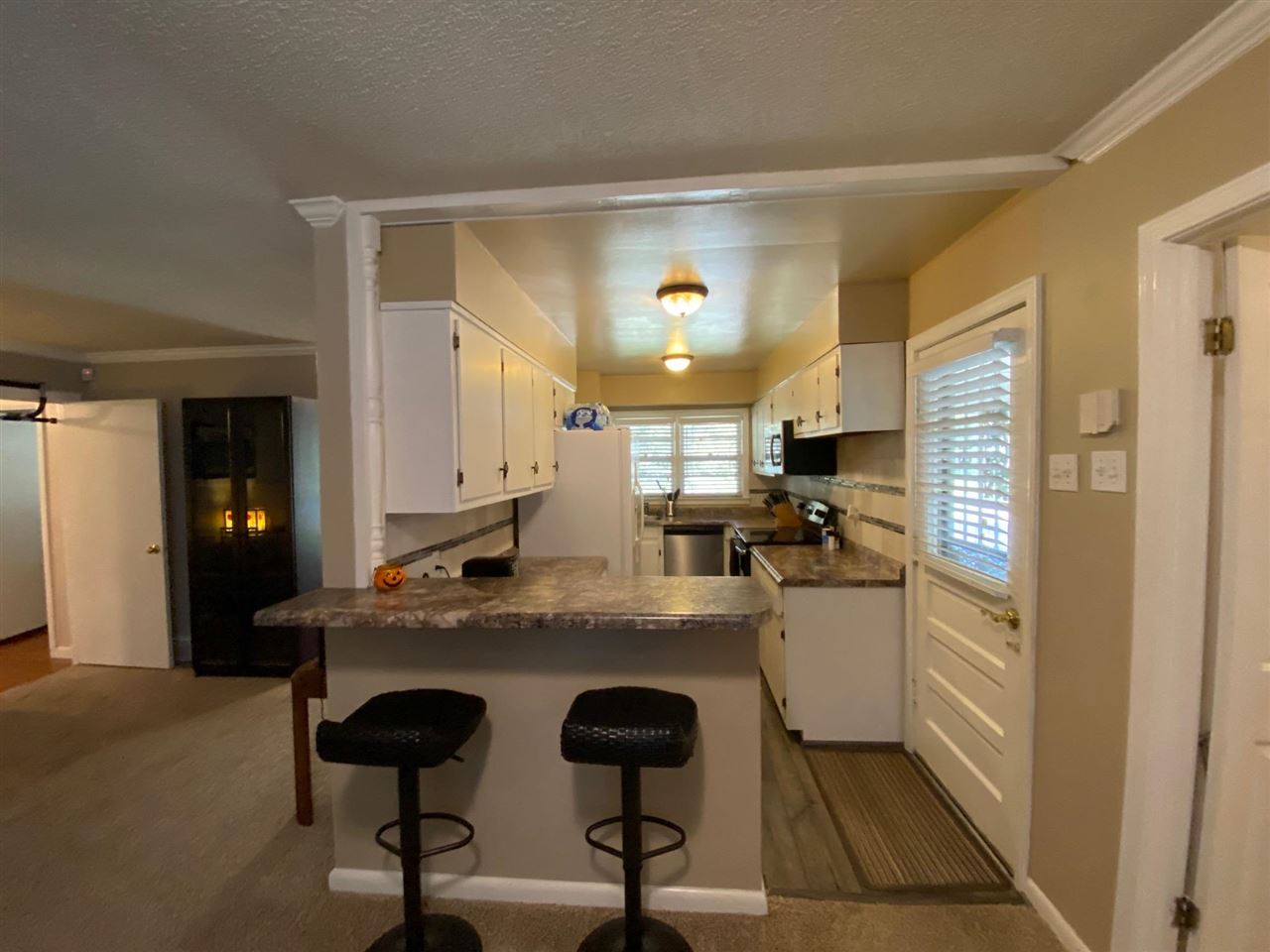 1265 Whitewater Road Memphis, TN 38117 - Photo 5 of 23 a kitchen with kitchen island granite countertop a stove and white cabinets