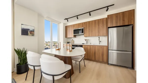 a kitchen with stainless steel appliances a refrigerator and a dining table