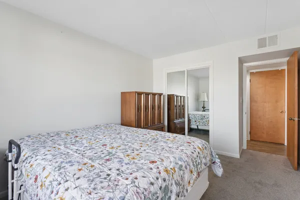 a bedroom with a large bed and a closet