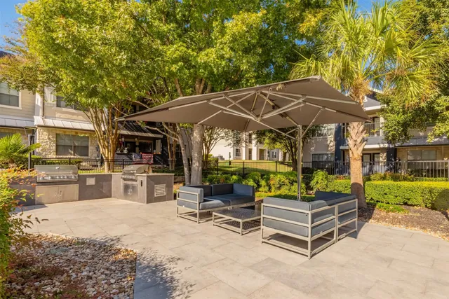 a view of a patio with a table and chairs under an umbrella