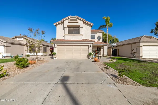 a view of a white house with a yard and potted plants