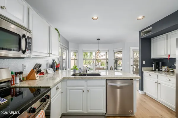 a kitchen with a sink stove top oven and cabinets