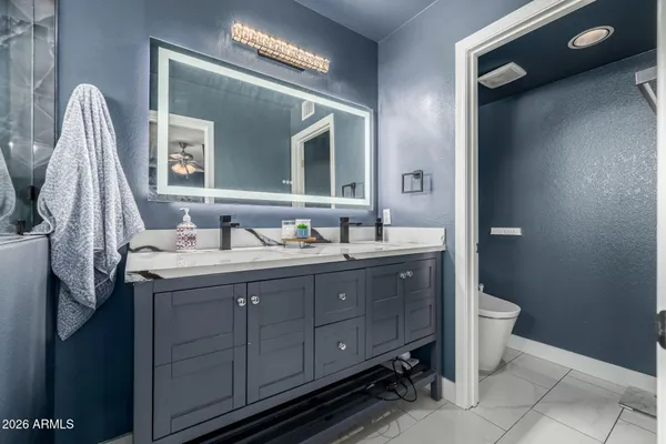 a bathroom with a double vanity sink and a toilet