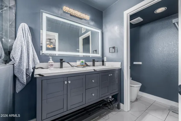 a bathroom with a double vanity sink and a toilet
