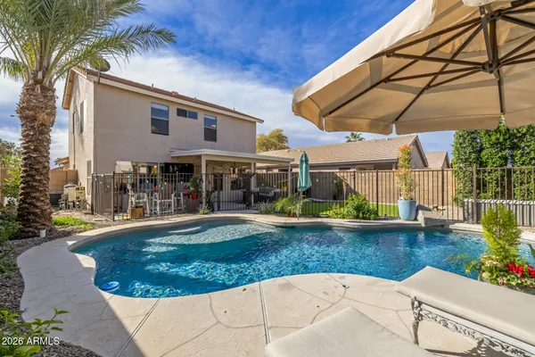 a view of a house with swimming pool and sitting area