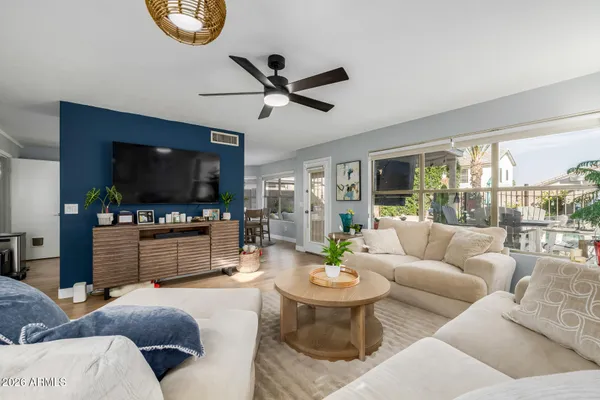 a living room with furniture a flat screen tv and a large window