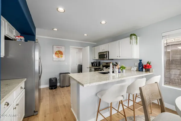 a kitchen with stainless steel appliances kitchen island granite countertop a refrigerator and microwave