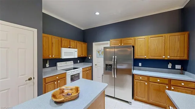 a kitchen with stainless steel appliances granite countertop a refrigerator a stove and a sink with wooden floor