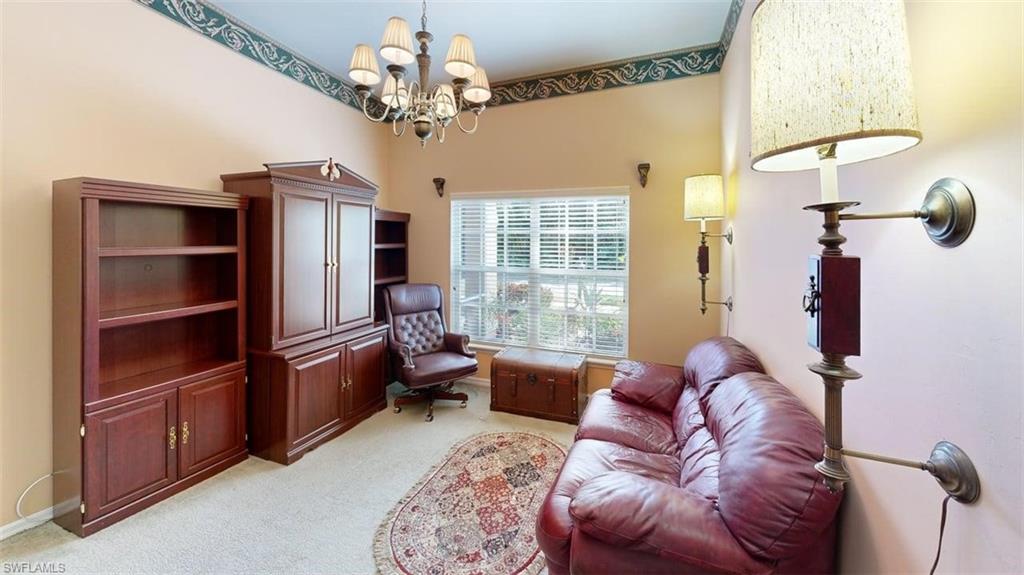 285 Spider Lily Lane Naples, FL 34119 - Photo 31 of 50 a living room with furniture a chandelier and a flat screen tv