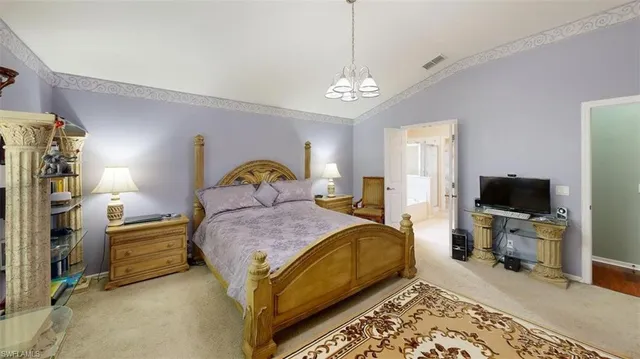 a bedroom with a bed and a flat tv screen on the dresser