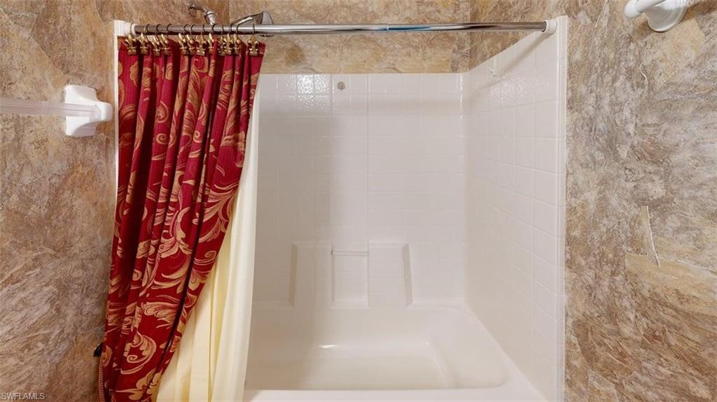 285 Spider Lily Lane Naples, FL 34119 - Photo 41 of 50 a bathroom with a shower curtain and a window
