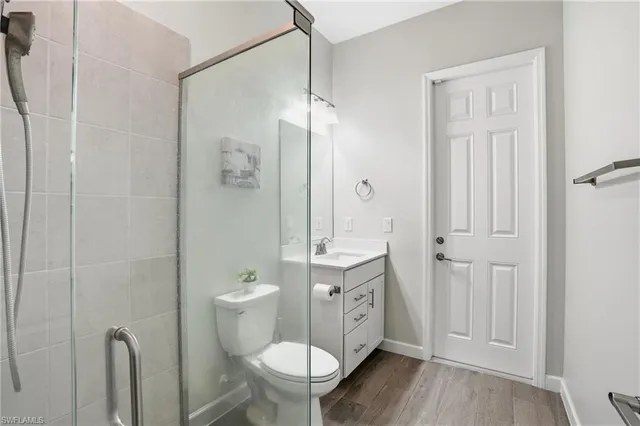 a bathroom with a granite countertop toilet a sink a shower and a mirror