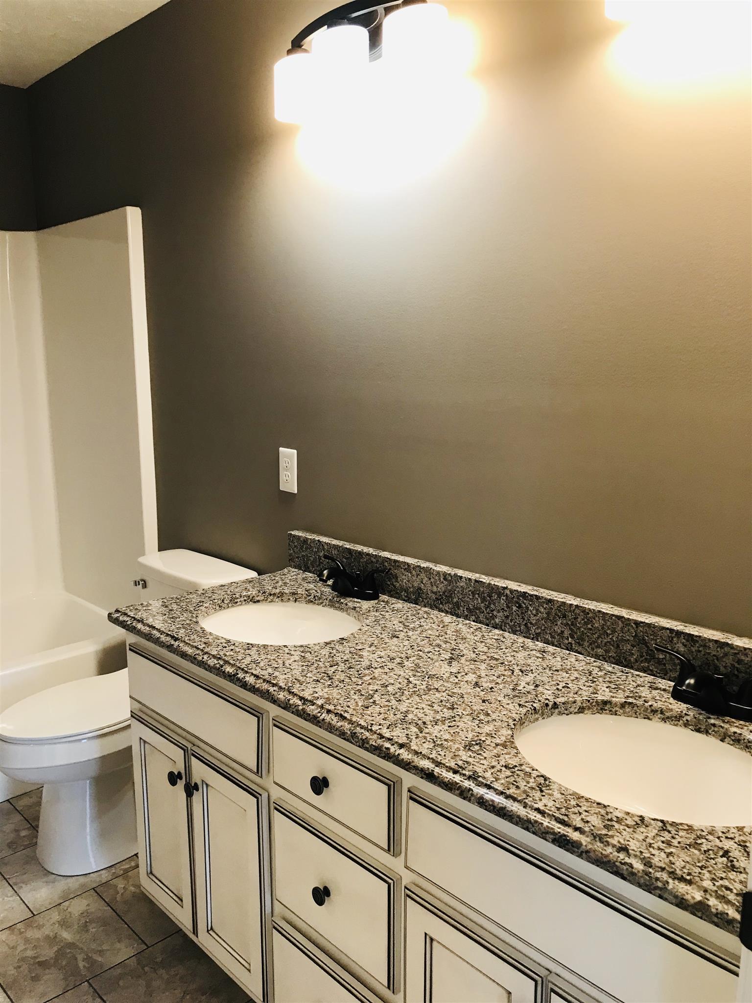 426 Fowler Ford Road Portland, TN 37148 - Photo 15 of 19 a bathroom with a granite countertop sink and a toilet