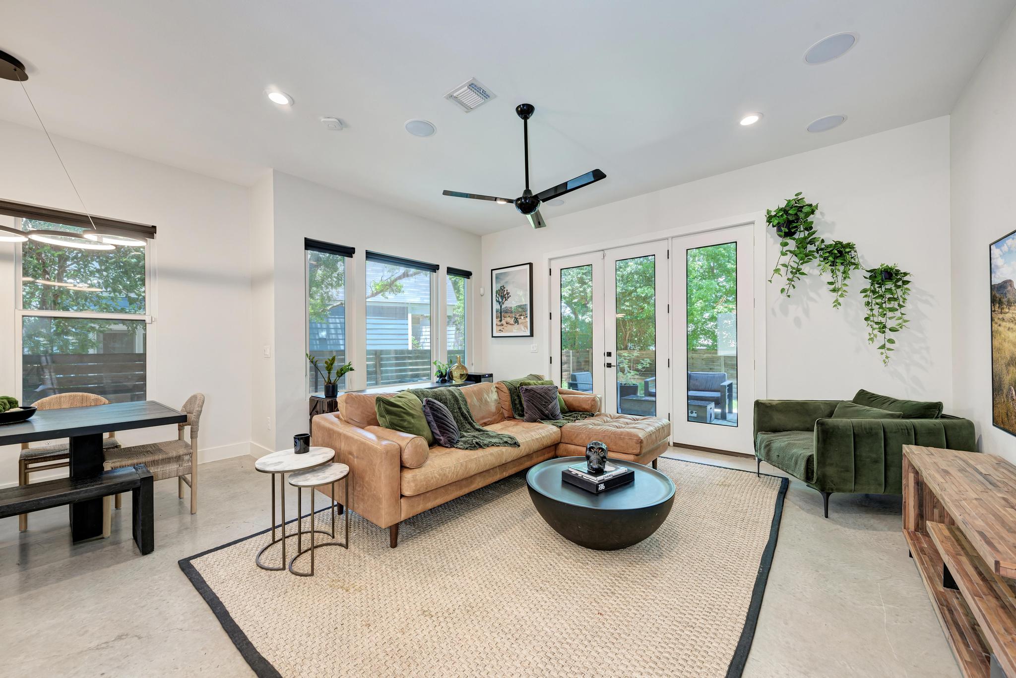 918 Cardinal Lane, Unit A Austin, TX 78704 - Photo 13 of 40 Oversized windows pull in soft natural light and frame leafy views, while polished concrete floors and tall ceilings give the main level a clean, gallery-like feel.