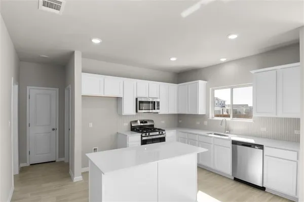 a kitchen with granite countertop white cabinets and white appliances