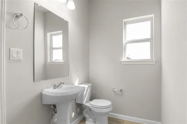 a bathroom with a sink toilet and a mirror