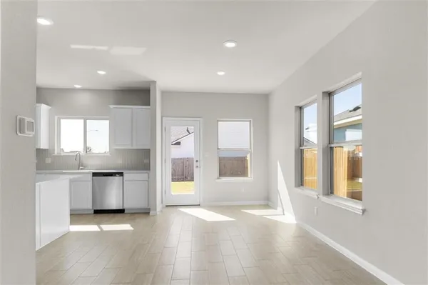 a open kitchen with granite countertop a sink and dishwasher a stove top oven with wooden floor